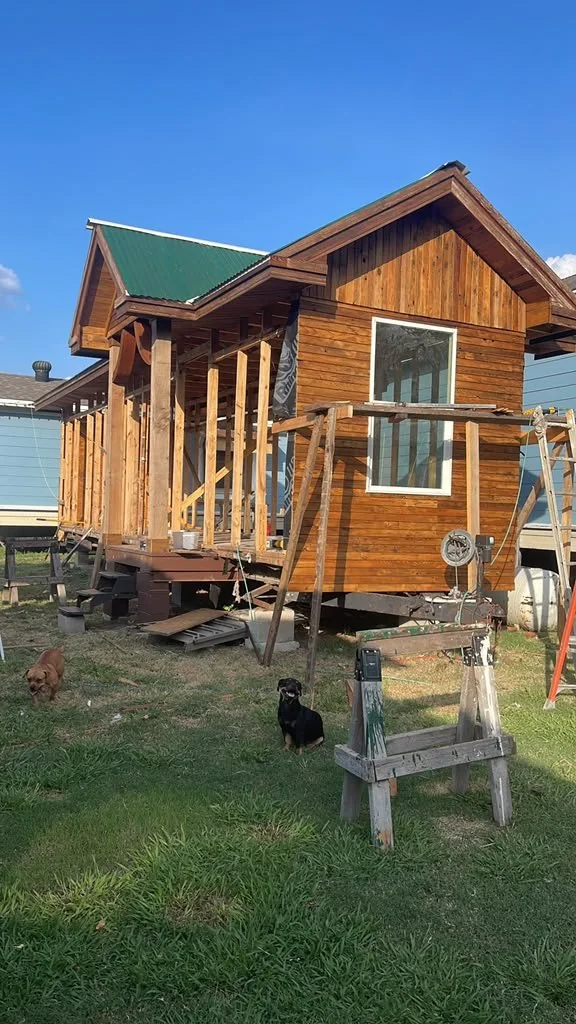 Cedar cabin with a green metal roof, set and levelled